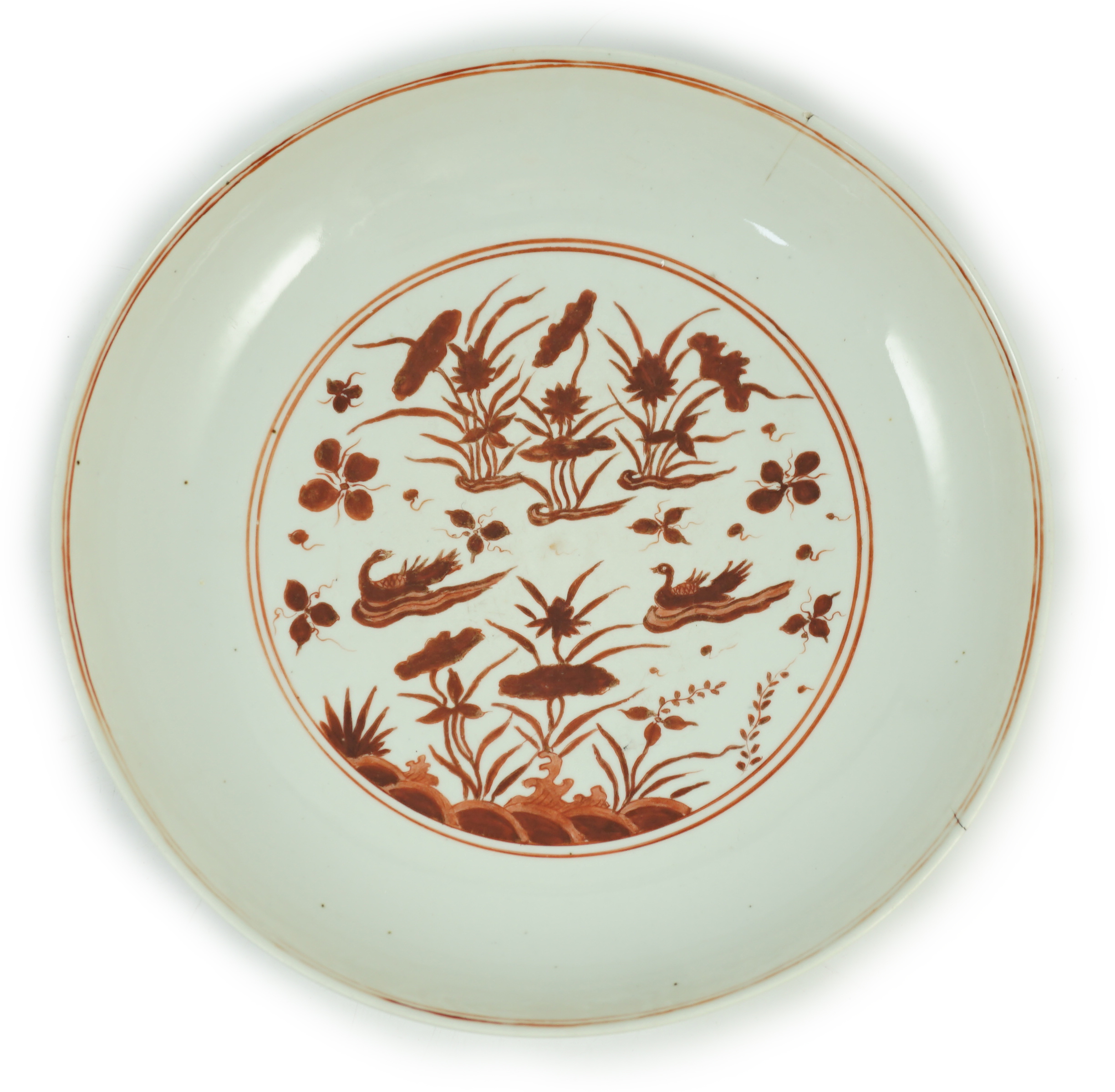 A large Chinese iron red enamelled ‘lotus pond’ dish, Wanli mark and possibly of the period, two short cracks